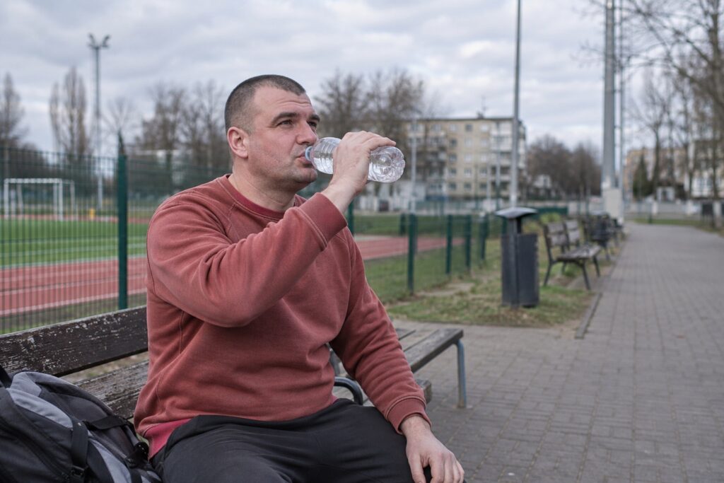 Mężczyzna odpoczywający na ławce przy boisku
